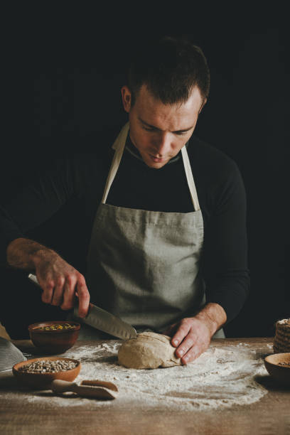 istock Young man making bread on wooden table 1404875024