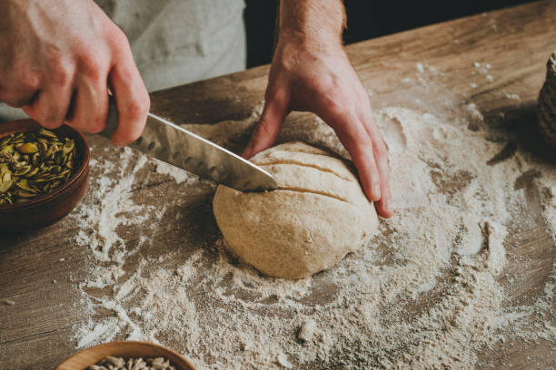 istock Young man making bread on wooden table 1404875038