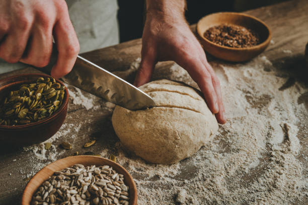 istock Young man making bread on wooden table 1404875084