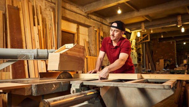istock Professional carpenter in uniform works on a woodworking machine at the carpentry manufacturing 1404876476