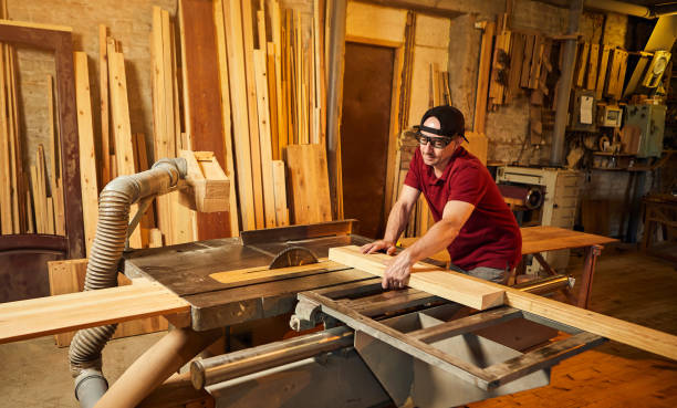 istock Professional carpenter in uniform works on a woodworking machine at the carpentry manufacturing 1404876585