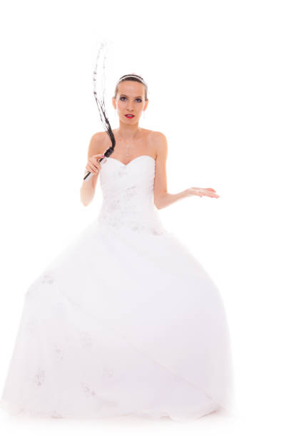 Wedding day. Full length young attractive bride in white dress with black leather flogging whip isolated on white background