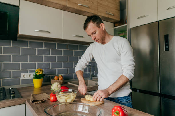 istock Young man cooking vegetables in the kitchen 1404877483