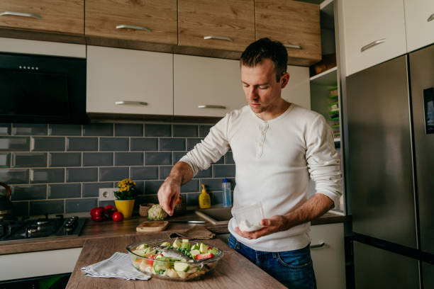 istock Youth man cooking fish and vegetables in the kitchen 1404878048