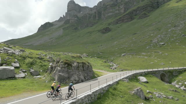 Aerial view of cyclists ascending mountain road