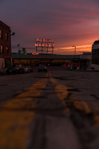 Seattle, USA - Jun 17, 2022: The famous neon public market sign at Pike Place Market with a brilliant sunset.