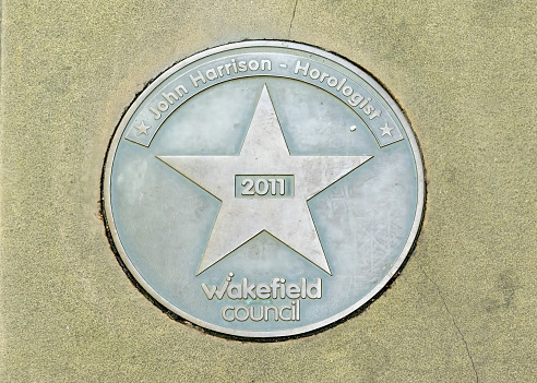 Wakefield Star on Walk of Fame.  This is in the centre of Wakefield, Yorkshire, England, UK on the pavement and is for John Harrison, clockmaker.  John Harrison was a clockmaker who invented the marine chronometer, solving the problem of calculating longitude while at sea. Harrison's solution revolutionized navigation and increased the safety and accuracy of long-distance sea travel.