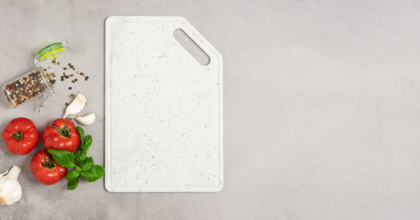 istock Marble white cutting board ripe tomatoes basil garlic gray background. Ingredients fresh vegetables 1404880729