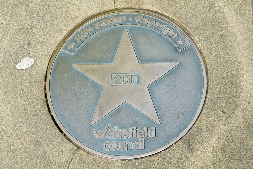 Wakefield Star on Walk of Fame.  This is in the centre of Wakefield, Yorkshire, England, UK on the pavement and is for John Godber - playwright, he is third most performed playwright in the UK behind William Shakespeare and Alan Ayckbourne.