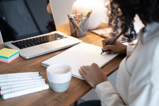 istock Beautiful young mixed race creative designer woman using pen tablet and laptop 1404882250