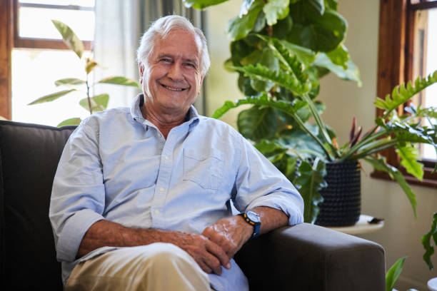 istock Smiling senior man sitting on his living room sofa 1404883488