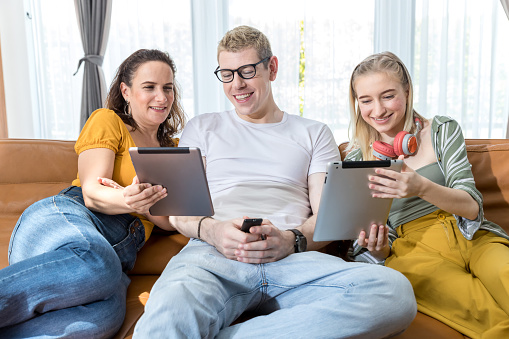 Family smiling in front of camera during live streaming in social network. Family time together at home. Happy Family making online call using Tablet or mobile.