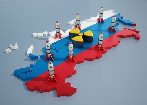 Group of nuclear weapons and radiation symbol on Russia map in Russian flag colors.