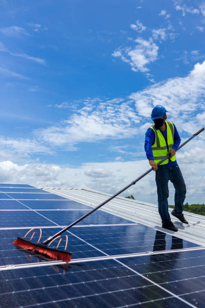 istock Worker Cleaning solar panels with brush and water. Worker cleaning solar modules in a Solar Energy Power Plant 1404884107