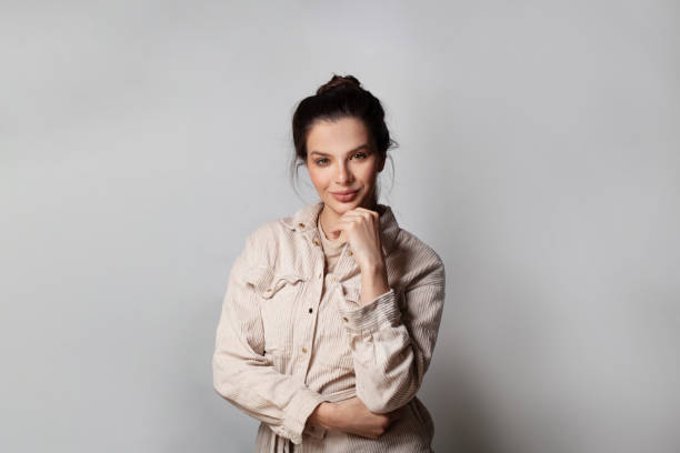 istock Happy young woman posing over grey wall background. 1404884853