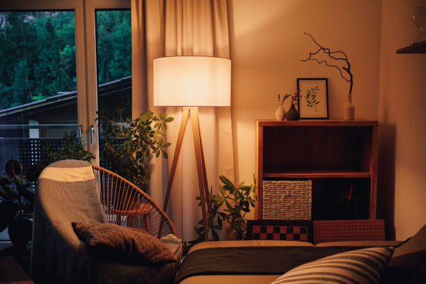 blick auf stativlampe in einem gemütlichen wohnzimmer verbringen warmes licht - elektrische lampe stock-fotos und bilder