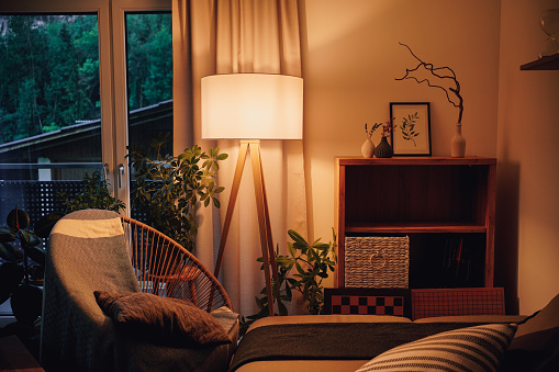 Vista de la lámpara de trípode en una acogedora sala de estar gastando luz cálida photo