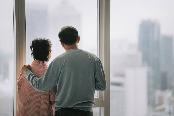 istock Rear view Asian chinese senior couple holding coffee cup looking through window on skyscraper 1404886845
