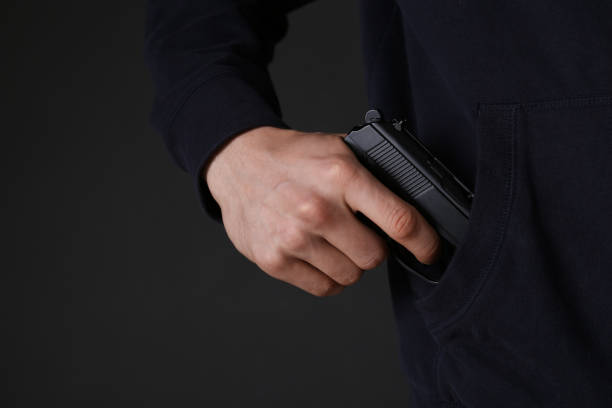 istock Man hiding gun in pocket against dark background, closeup 1404888121