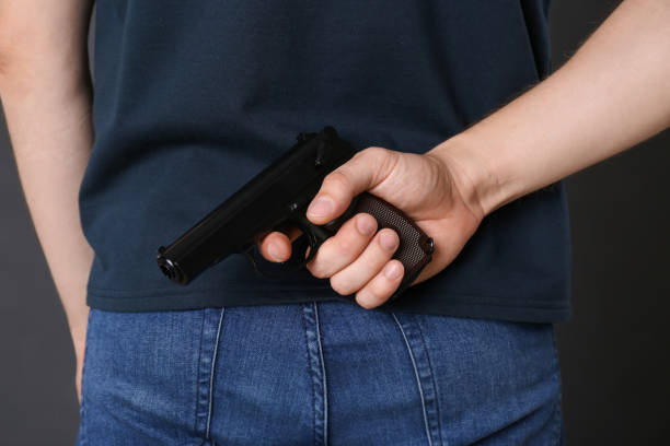 istock Man hiding gun behind his back, closeup view 1404888122