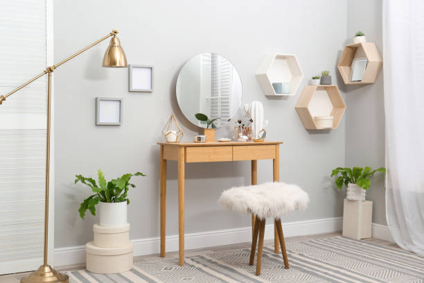 istock Stylish room interior with wooden dressing table and mirror on light wall 1404888242