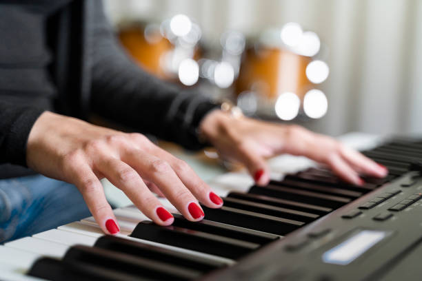 istock Young woman playing digital keyboard or electronic piano on concert stage 1404892017