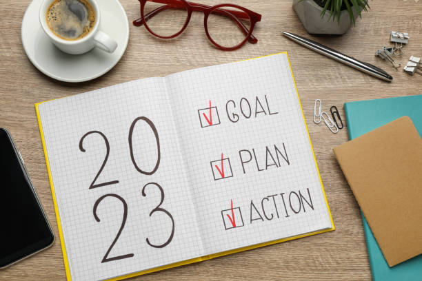 istock Flat lay composition of notebook with text 2023 Goal, Plan, Action on wooden table. New year resolutions 1404892844
