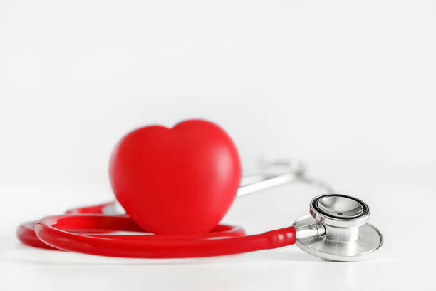 красный стетоскоп и красное сердце на белом фоне - black and white heart shape metallic red стоковые фото и изображения