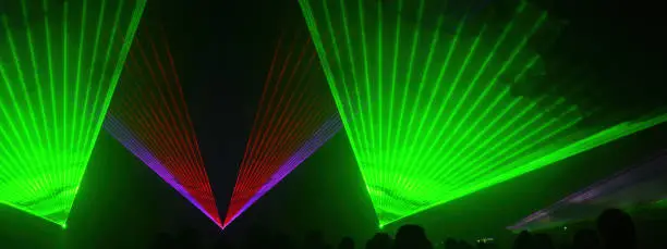 Lasershow festival disco  party background banner panorama - Colorful outdoor laser show with rays streams and crowd silhouette of party people