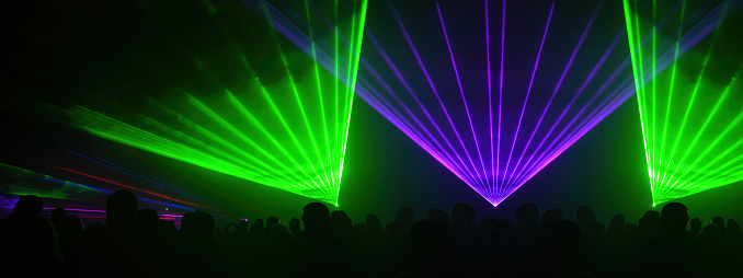 Lasershow festival disco  party background banner panorama - Colorful outdoor laser show with rays streams and crowd silhouette of party people