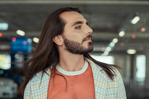 Handsome man with long hair posing outdoors