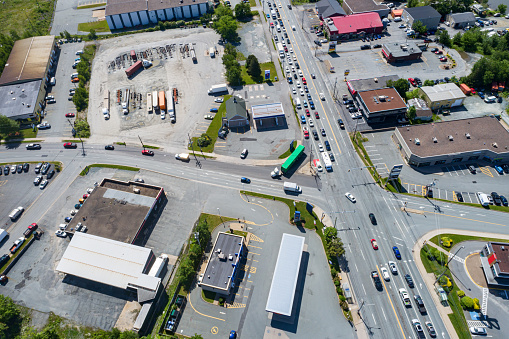Aerial drone view of a retail/industrial park with heavy traffic.