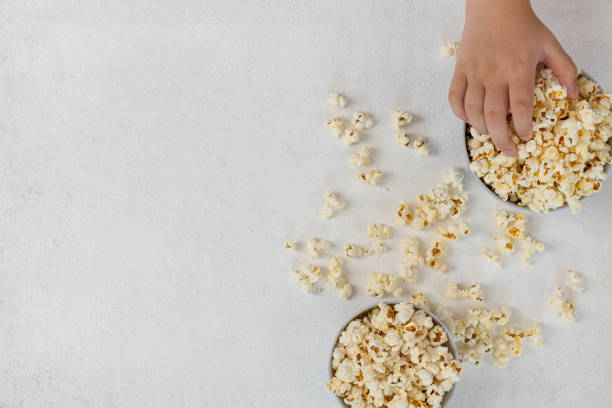 istock A bowl of delicious popcorn on a light background, top view, copy space 1404901370