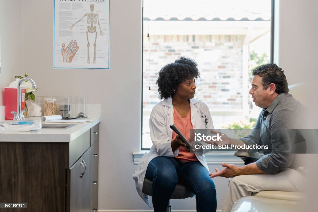 Billing coordinator meets with patient The medical billing coordinator meets with the patient to discuss payment options for his upcoming procedure. Doctor Stock Photo