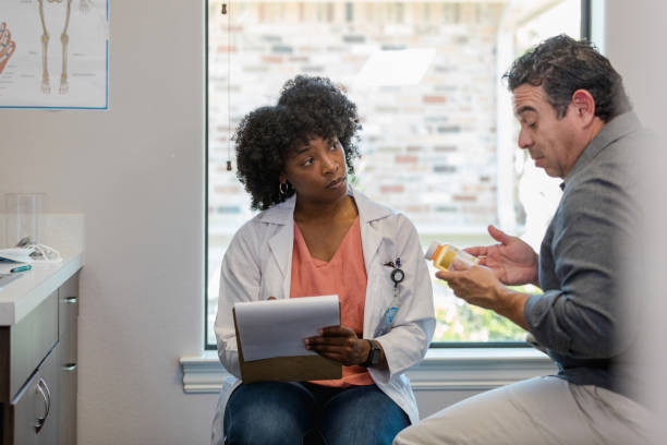 istock Doctor takes notes while male patient describes drug side effects 1404901802