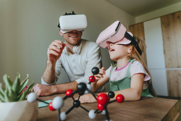 istock Little girl having fun time with her father using VR glasses 1404904641