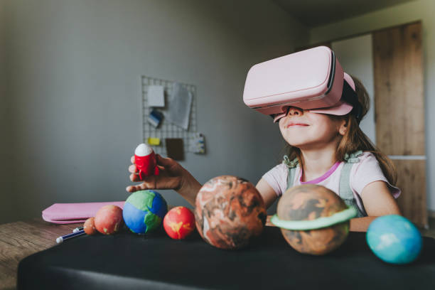 istock Little girl using VR glasses at home for learning Solar system planets 1404904776