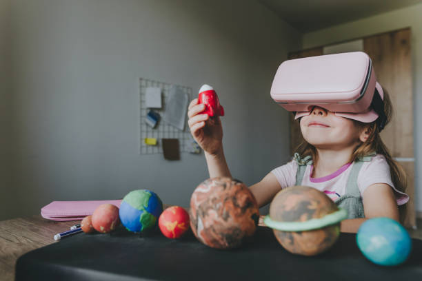 istock Little girl using VR glasses at home for learning Solar system planets 1404904777