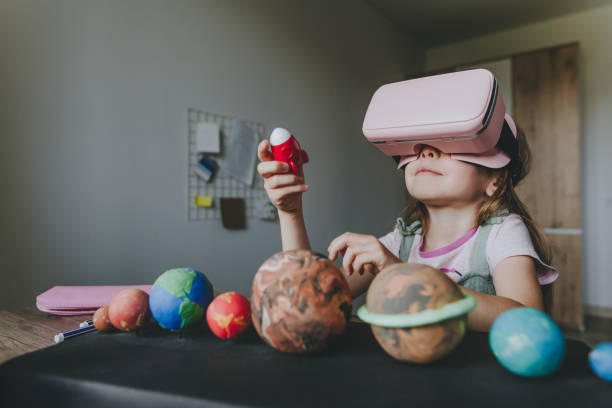 istock Little girl using VR glasses at home for learning Solar system planets 1404904780