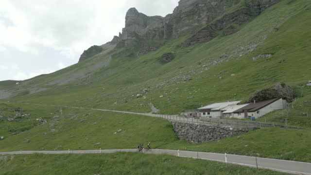 Aerial view of cyclists ascending mountain road