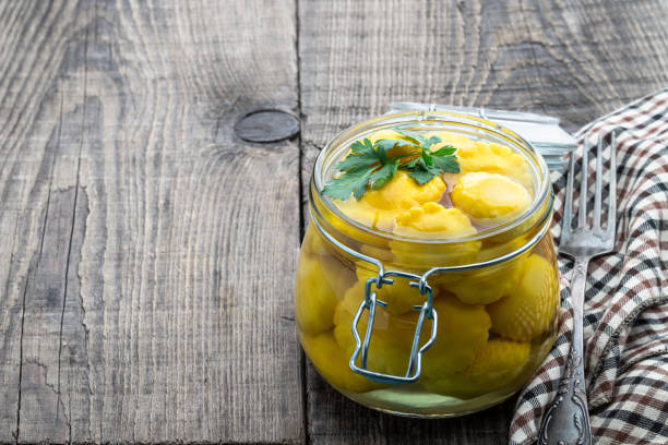 istock Marinated yellow squash in glass jar on wooden table 1404906067