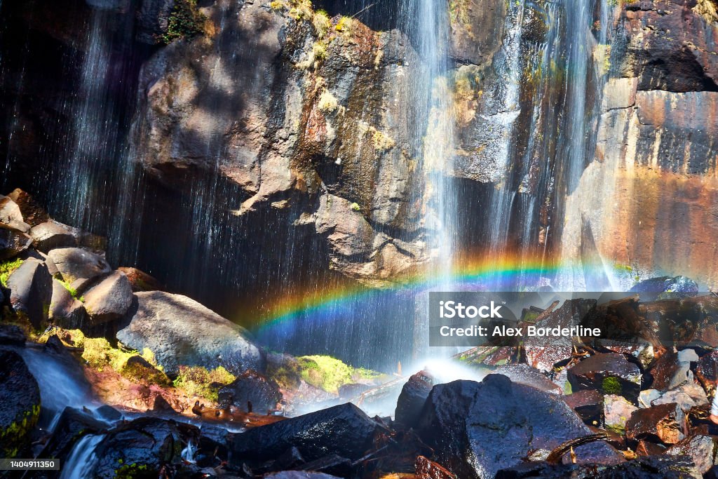 Waterfall with a rainbow and large rocks in a natural landscape in Mexiquillo Durango in the Sierra Madre Occidental Waterfall in the foreground with a rainbow and large rocks wet with moss in mexiquillo Durango in the Sierra Madre Occidental Nature Stock Photo