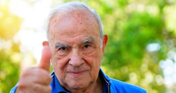 Smiling senior man posing with his thumb up