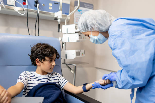 niño en quimioterapia mirando a una enfermera encontrando una vena en su brazo - intravenous infusion fotografías e imágenes de stock