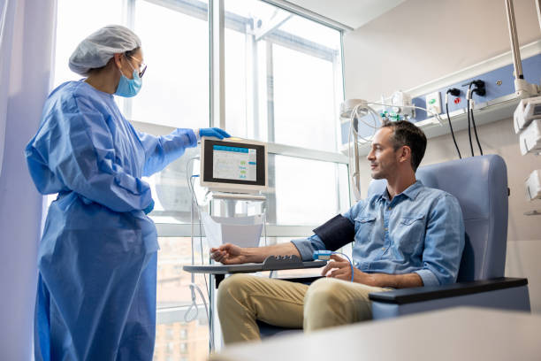 Oncology nurse checking the vital signs of a chemotherapy patient Oncology nurse checking the vital signs of a chemotherapy patient at the hospital - cancer treatment concepts cancer treatment stock pictures, royalty-free photos & images