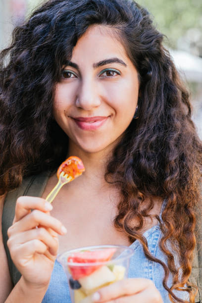 istock Happy Hispanic female eating fruits 1404917227