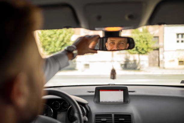 istock Serious businessman driving a car looking at rearview mirror 1404920617