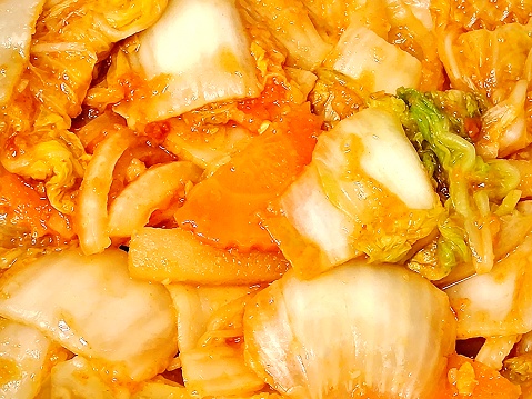 Korean Cuisine, Close Up of Kimchi or Seasoned Vegetables with Spicy Sauce. A Famous Traditional Side Dish of Salted and Fermented Vegetables.