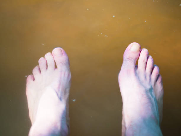 istock men's legs are lowered in muddy river water close-up 1404921270