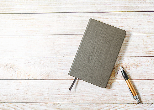 Notebook with pen on wooden table, vintage picture tone, ready to add text or layout, stock photo